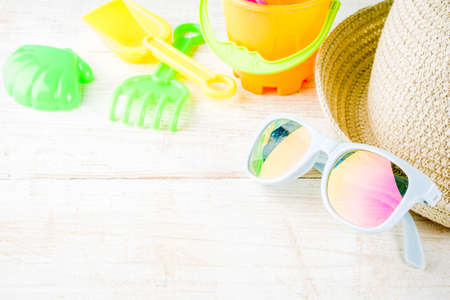 Summer holidays vacation concept background, hat, sunglasses, sand toys, white wooden background copy space の写真素材