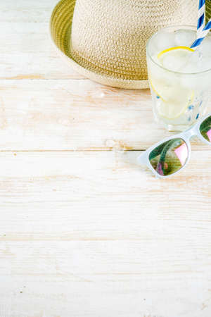 Summer holidays vacation concept background, hat, sunglasses, iced drink (lemonade, mojito), white wooden background copy space の写真素材