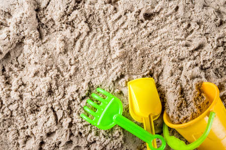 Summer vacation concept, Children's holidays background, sea sand and beach bright plastic toys, top view copy spaceの写真素材