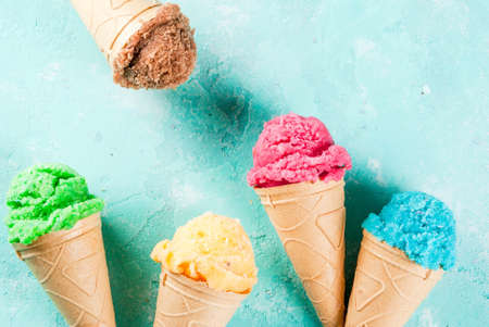 Selection of various bright multicolored ice-cream in ice cream cones - chocolate vanilla blueberry...