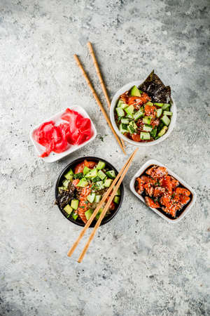 Asian trendy food, sushi poke bowl with cucumber, salmon, avocado, Black and White Sesame Seeds  