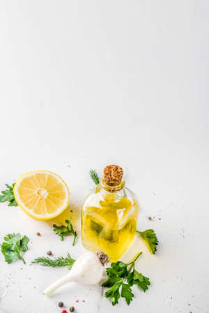 Cooking background with Fresh Vegetables for healthy dinner; carrots, herbs, olive oil, garlic; white marble background flat layの写真素材