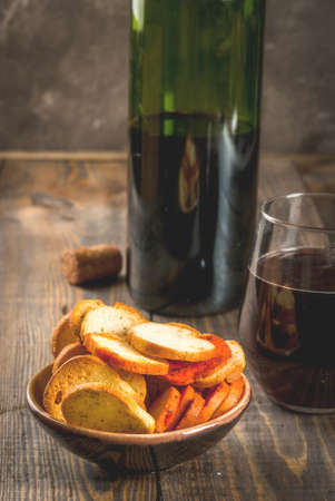 Assorted Italian brusquette crackers - with mushrooms, pesto and tomatoes - with wine in glass and...