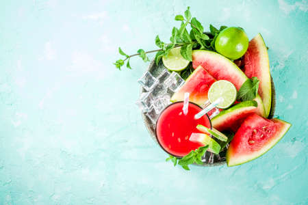 Fruity summer cold drink, homemade watermelon juice or smoothie served with lime and fresh mint leaves, light blue trendy background copy space top viewの写真素材