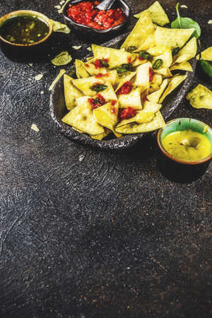 Mexican food, nachos snack with salsa and sauces on dark rusty background top view copy spaceの写真素材