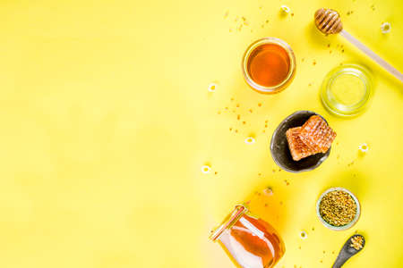 Organic floral honey, in jars, with pollen and honey combs, with wildflowers creative layout bright...