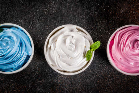 Healthy diet summer dessert, vanilla and berry frozen yogurt or  soft ice cream in white bowls, white marble background copy space aboveの写真素材