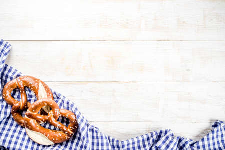 Oktoberfest food menu, bavarian pretzels with beer bottle mug, white wooden background copy space top viewの写真素材