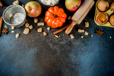 Sweet autumn baking cooking background with flour, rolling pin, decorative pumpkins, apples,...