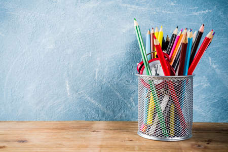 Back to school concept with pencils and alarm clock on wooden desk, copy space