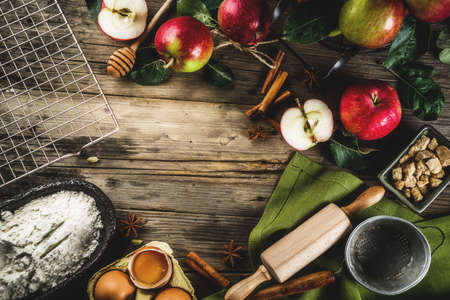 Autumn cooking background, Apple pie baking concept, fresh red apples, sweet spices, sugar, flour, rolling pin, eggs, baking utensils, wooden background copy spaceの写真素材
