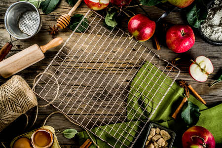 Autumn cooking background, Apple pie baking concept, fresh red apples, sweet spices, sugar, flour, rolling pin, eggs, baking utensils, wooden background copy spaceの写真素材