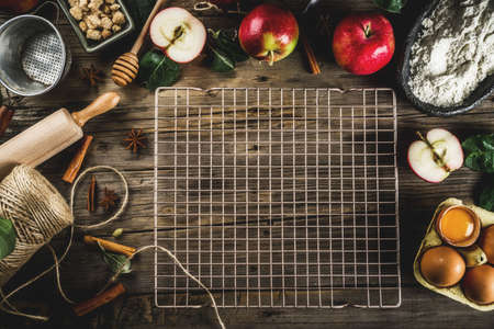 Autumn cooking background, Apple pie baking concept, fresh red apples, sweet spices, sugar, flour, rolling pin, eggs, baking utensils, wooden background copy spaceの写真素材