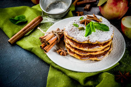 Sweet and spicy autumn apple pancakes, with anise, cinnamon and sugar, dark blue background copy...