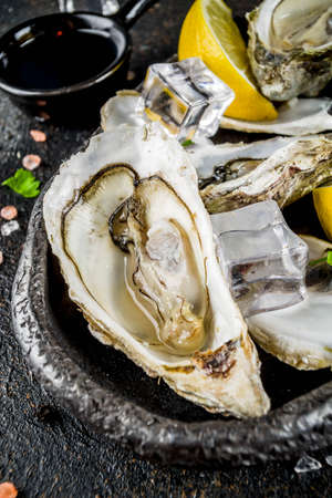 Fresh raw seafood, oysters with lemon and ice on a light blue backgroundの写真素材