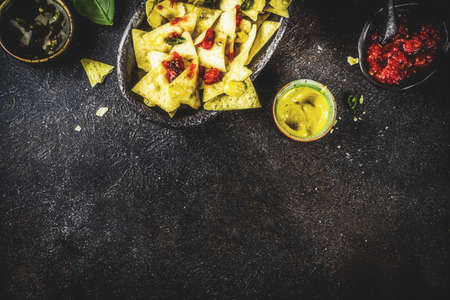 Mexican food, nachos snack with salsa and sauces on dark rusty background top view copy spaceの写真素材