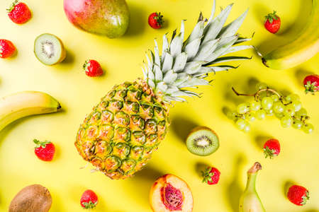Various tropical fruit background pineapple, banana, mango, strawberry, apples, peach, nectarine, creative layout copy space top viewの写真素材