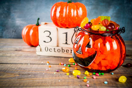 Halloween celebration concept with pumpkin decoration, candy, jack o lantern cup and old retro...