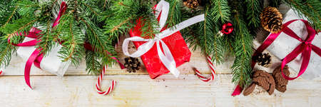 Christmas background with decorations, chocolate cookies and gift boxes on wooden background top...