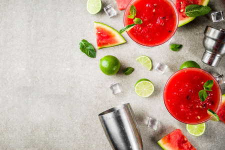 Watermelon margarita cocktail with lime and sliced watermelon, light concrete background copy spaceの写真素材