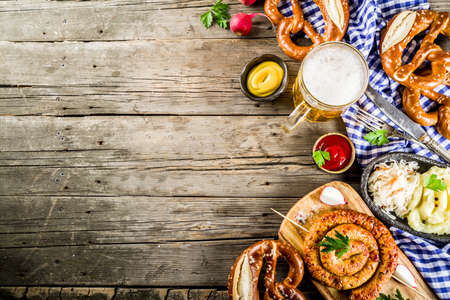 Oktoberfest food menu, bavarian sausages with pretzels, mashed potato, sauerkraut, beer bottle and mug old rustic wooden background, copy space aboveの写真素材