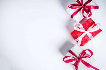 Christmas background for greeting card, with fir tree branch and gifts boxes with ribbons, on white...