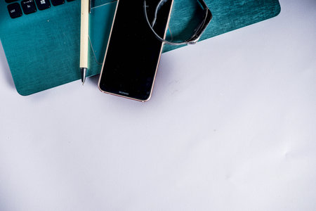 Workplace table with supplies, office concept with notepad, laptop, smartphone, Flat lat light grey background, top view copy space for textのeditorial素材