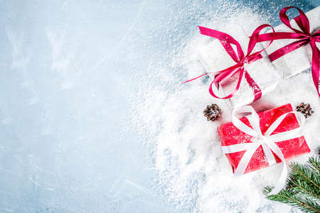 Christmas background for greeting card, with Christmas tree branches, decoration and gifts boxes with ribbons, on white background top view copy space for textの写真素材