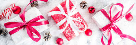 Christmas background for greeting card, with Christmas tree branches, decoration and gifts boxes with ribbons, on white background top view copy space for text bannerの写真素材