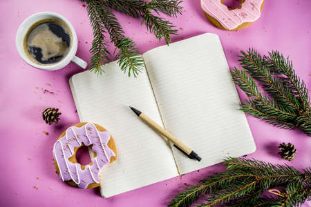 Rest and relaxation concept, coffee cup and biscuits donut with sugar coating, with a notepad for notes or wishes on a bright trendy background, top view space for textの写真素材