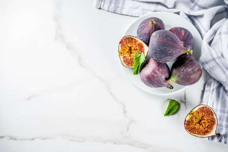 Raw fresh figs fruits on white marble background copy space