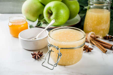 Homemade apple jam or sauce, with green apples and spices, white marble background copy spaceの写真素材