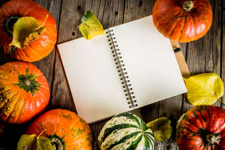 Autumn harvest concept, pumpkins background with yellow leaves, old rustic wooden table copy spaceの写真素材