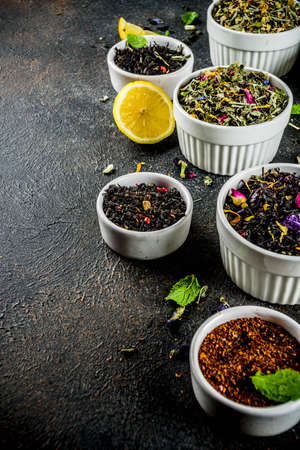 Assortment of various dry tea - classic black and green, flower, fruit, berry and herbal tea blends, with lemon and mint, White marble background copy space top viewの写真素材