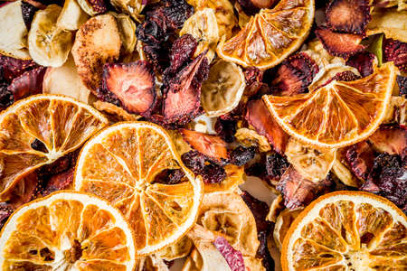 Home autumn harvest, dried fruits and berries in glass jars for canned preserves, strawberries, raspberries, apples, bananas, oranges, light concrete background, copy spaceの写真素材