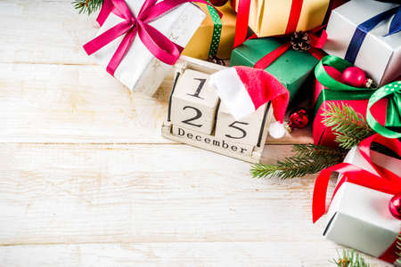 Christmas festive background with decorations and colorful gift boxes on wooden board