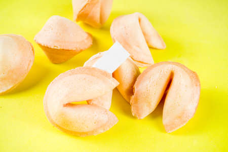 Chinese fortune cookie with prediction on bright yellow background top view copy spaceの写真素材