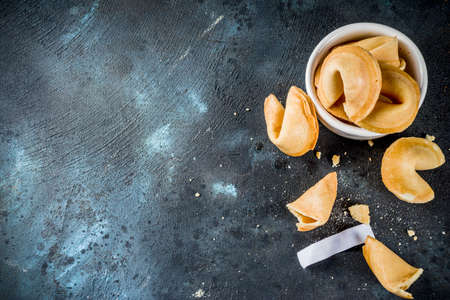 Chinese fortune cookie with prediction on dark blue concrete background  copy space