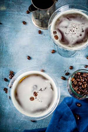 Coffee drink ideas, espresso martini cocktail, two glasses on blue concrete background copy space