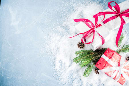 Christmas background for greeting card, with Christmas tree branches, decoration and gifts boxes with ribbons, on white background top view copy space for textの写真素材