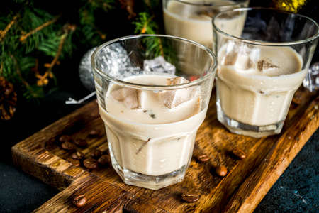 Irish cream cocktail or liqueur, traditional winter christmas drink, dark rusty background with fir...
