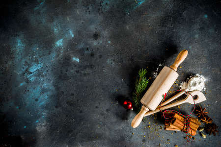 Christmas bakery background, with baking utensils, flour, spices and decorations, dark concrete...