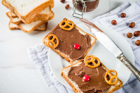 Chocolate and hazelnut spread sandwiches with white toasted bread, white marble background copy spaceの写真素材