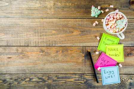 New years resolutions, colorful sticky notes with popular new year resolutions, wooden background...