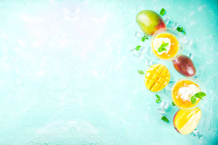 Tropical mango floating margarita cocktails with coconut ice cream, light blue background copy spaceの写真素材