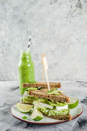 Vegan snack or lunch, healthy sandwiches with avocado and multigrain bread, on grey stone background...