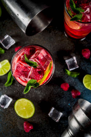 Iced summer drink cocktail, Raspberry and lime lemonade with fresh mint and lime, dark blue rusty background copy spaceの写真素材