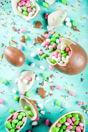 Colorful spring easter sweets background, with chocolate eggs, sugar sprinkles and marshmallow...