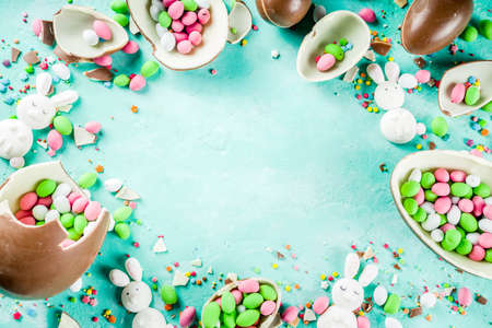 Colorful spring easter sweets background, with chocolate eggs, sugar sprinkles and marshmallow...