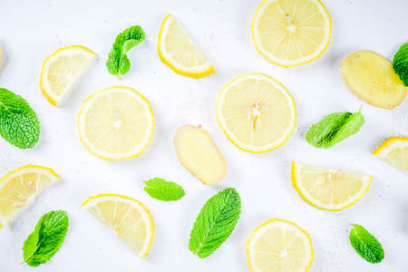 Mojito, lemonade cocktail or sour infused water ingredient. Flatlay with sliced lemon, ginger and mint leaves, layout on white background top view copy spaceの写真素材